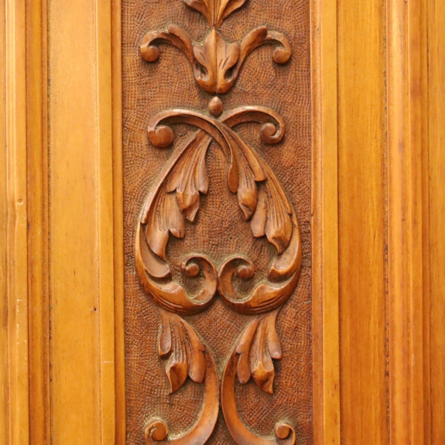 Edwardian walnut triple combination wardrobe, projecting pediment with pierced foliate scroll cresting above a central cupboard flanked by bevelled mirrored doors, over open recess with mirrored back, above two short and three long drawers with brass handles, interior fitted with hanging rails and shelf, raised on plinth base