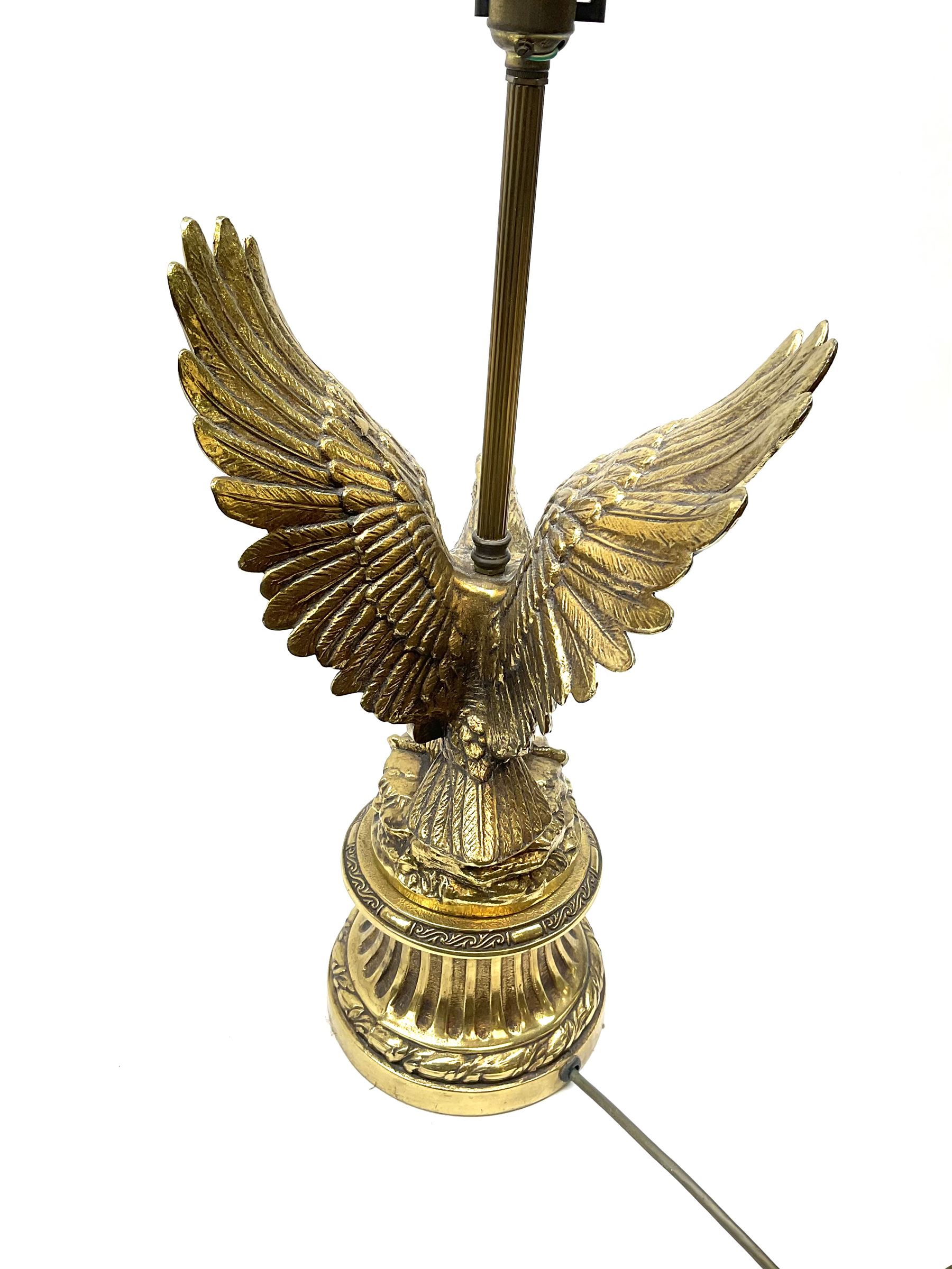 A brass table lamp modelled in the form of an eagle upon a circular base, overall H73cm.