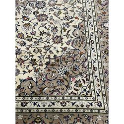 Persian Kashan ivory ground rug, central pointed rosette medallion surrounded by scrolling branches and stylised flower heads, the border with scrolling pattern decorated with palmettes, within guard stripes