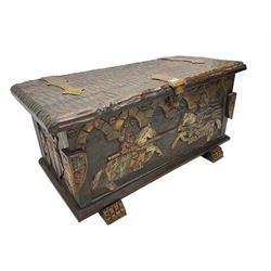 Carved wooden blanket chest, the tooled hinged lid with shaped metal strap hinges and catch, the front carved with arcade over two medieval jousters, on carved sledge feet