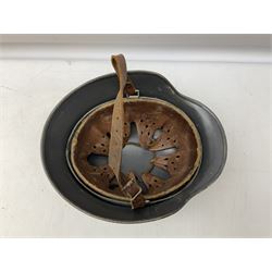 WW2 German steel helmet painted in undecaled Luftwaffe bluey grey with leather liner and chin strap stamped '58', the skirt impressed '1250'