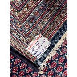 Northwestern Persian Bottehmir hand-knotted carpet, dark indigo field with an all-over design of boteh motifs arranged in diagonal rows, framed by multiple borders, main ivory border with stylized floral sprays between narrow geometric guard stripes, 362cm x 268cm