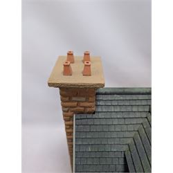 1:24 scale stone effect three-storey cottage dolls house, with green arched door and lattice effect windows, decorated to the interior with wooden floors, wired lighting and fire places, H45cm, W57cm, D26cm