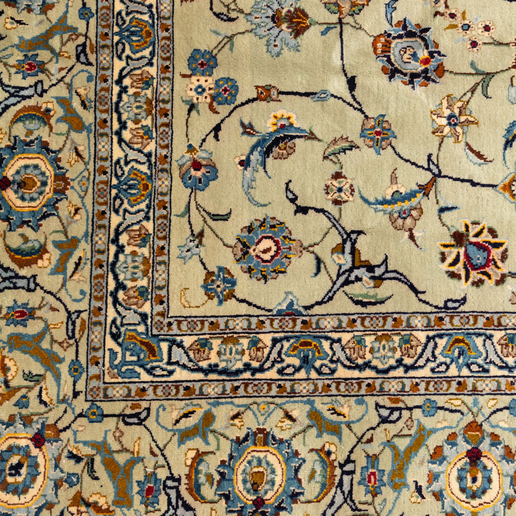 Persian Kashan rug, cream ground decorated with an all-over pattern of interlaced floral stems, rosettes and palmettes in blue, gold and rust tones, framed by layered floral borders, woven in the Kashan region of Iran