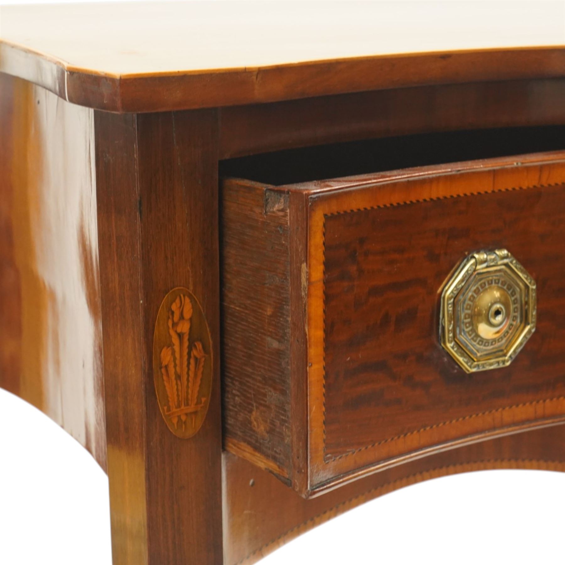 Ealy 19th century Sheraton design inlaid mahogany serpentine-fronted side table, shaped rectangular top with boxwood-inlaid edge, fitted with singe cock-beaded frieze drawer with satinwood cross-banding and herringbone stringing, fitted with original pressed brass octagonal handle plates, flanked by oval feather motif inlays, raised on square tapering supports
