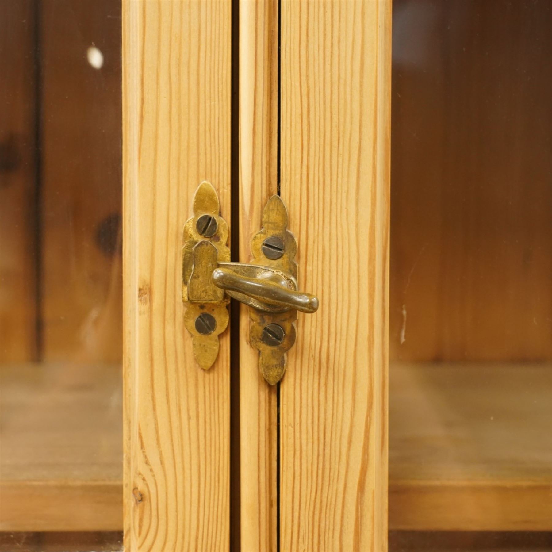 19th century pine glazed bookcase cupboard, twin astragal glazed doors with stained glass corner panels, enclosing fixed shelves, the lower section fitted with two panelled cupboard doors enclosing single shelf, on plinth base