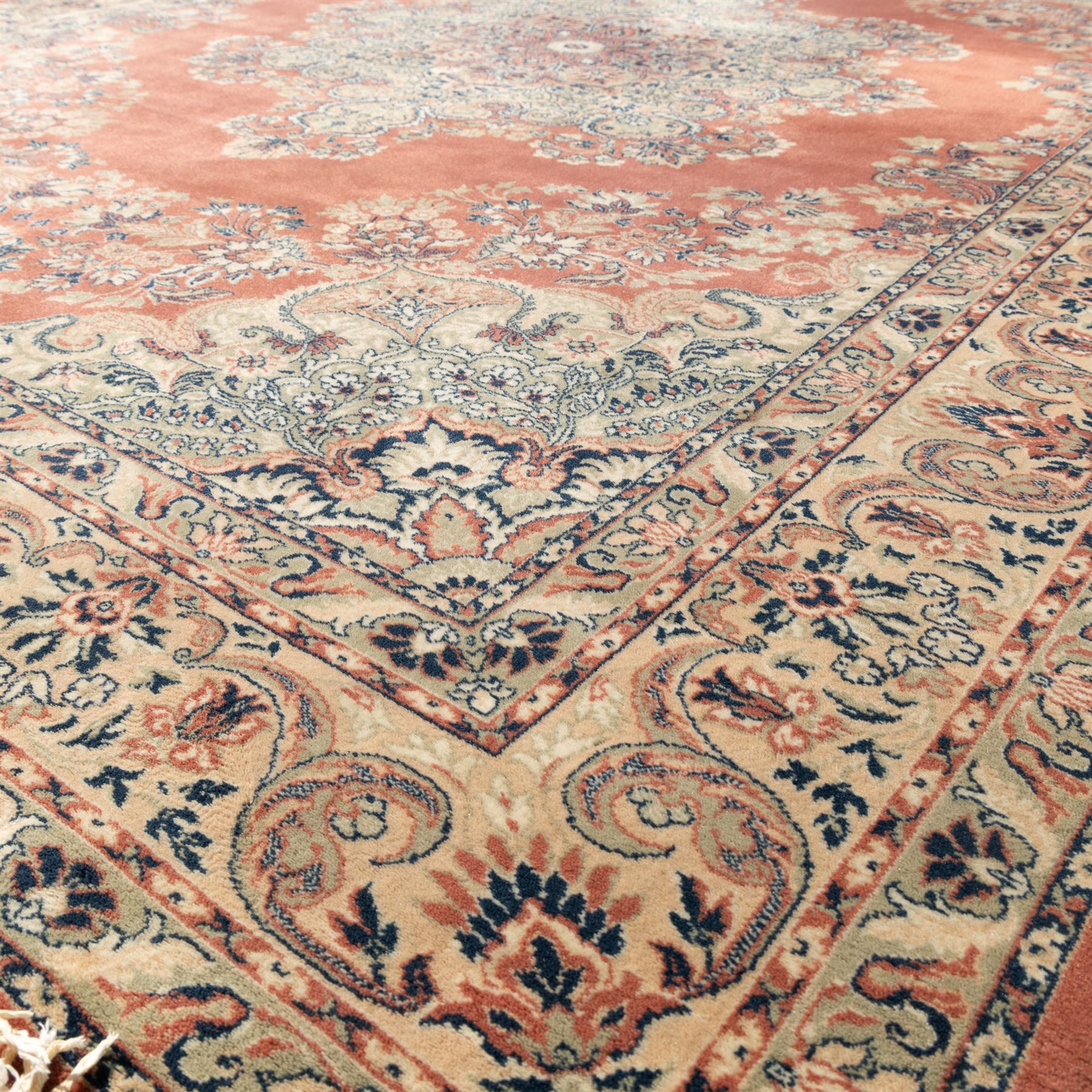 Persian Kashan rug, the rich terracotta field with central floral medallion and palmette spandrels, surrounded by a cream border of stylised boteh and foliate decoration