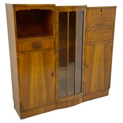 Early 20th century walnut side cabinet, enclosed by central bowed and glazed door, fitted with drawer, two cupboards and fall front, on plinth base