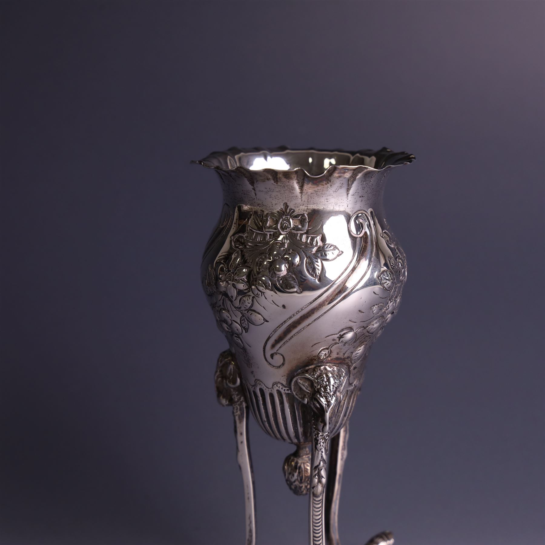 Late Victorian silver vase, of baluster form with fluted rim, the body with embossed floral decoration, upon three tall legs with ramshead mounts, hallmarked William Comyns & Sons, London 1890, H13.5cm