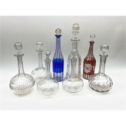 Group of glass decanters, to include blue overlaid example with slice cut decoration, and a ruby flashed example with fruiting vine and slice decoration, plus Victorian and later examples, (not all stoppers original).