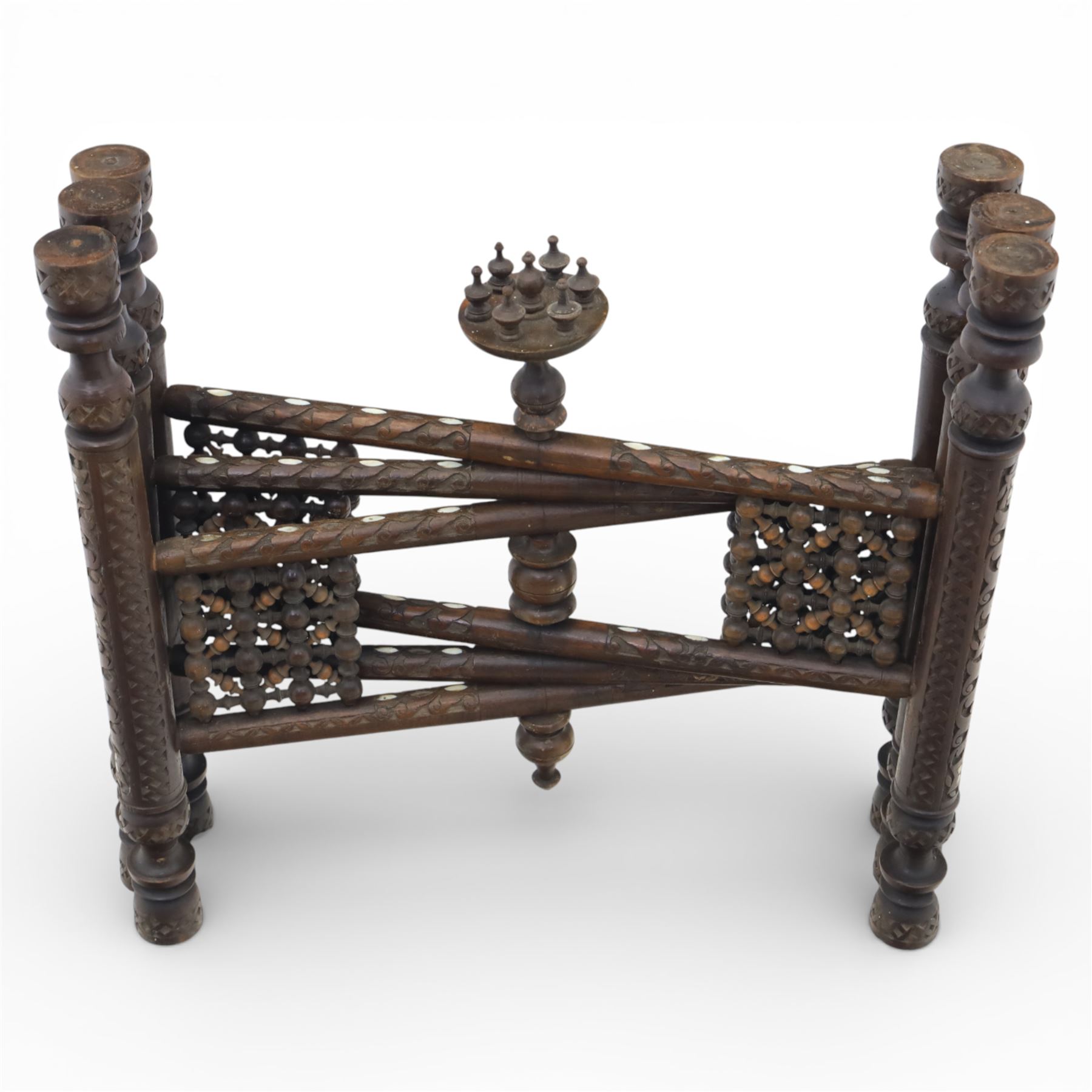 20th century Eastern brass charger topped table, the circular brass trap chased with an elephant, palm tress and flowering vines, supported upon a folding stand with six turned legs with inlaid detail, united by turned supports