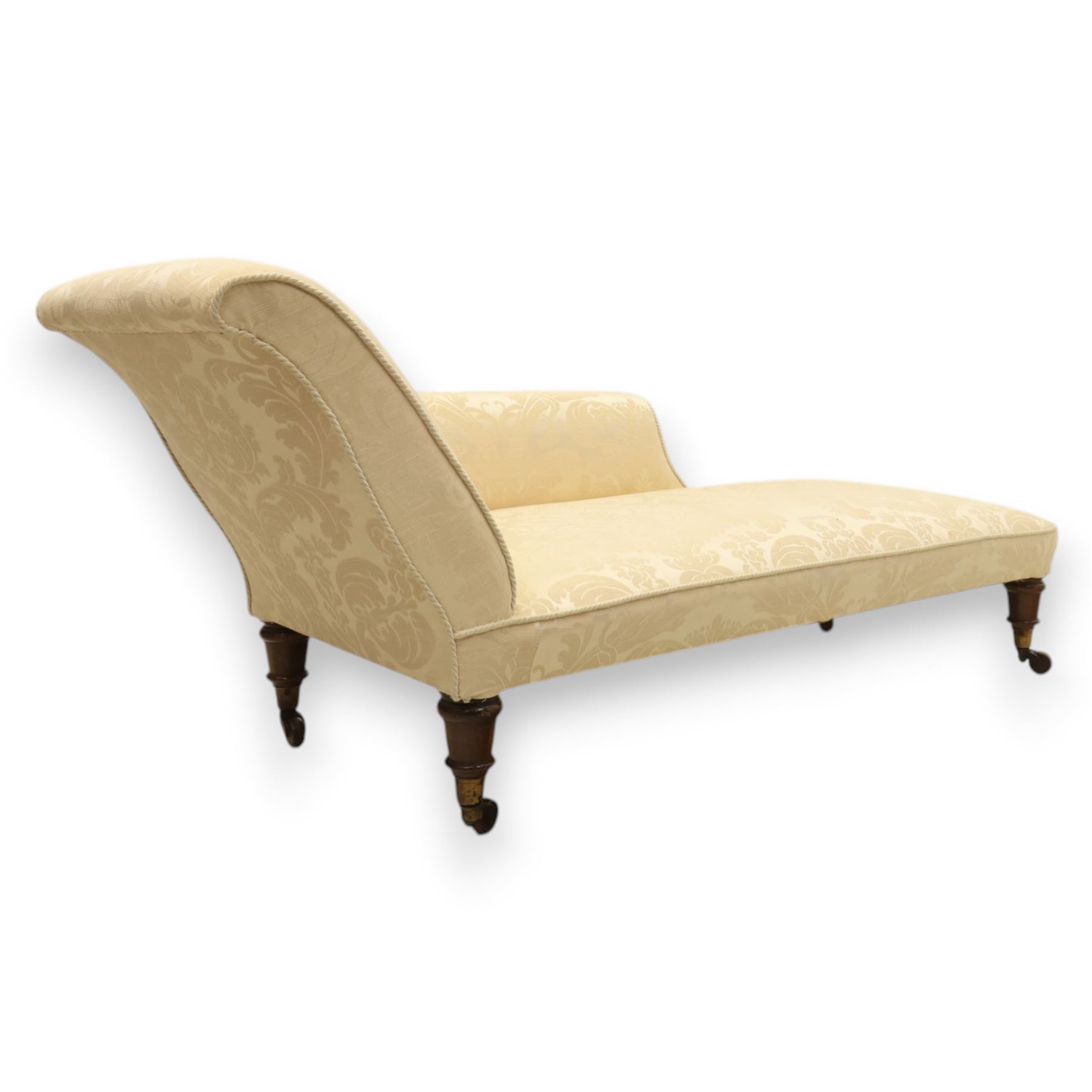 Victorian chaise longue upholstered in ivory damask fabric, padded back and armrest with rope piping, raised on turned feet with castors