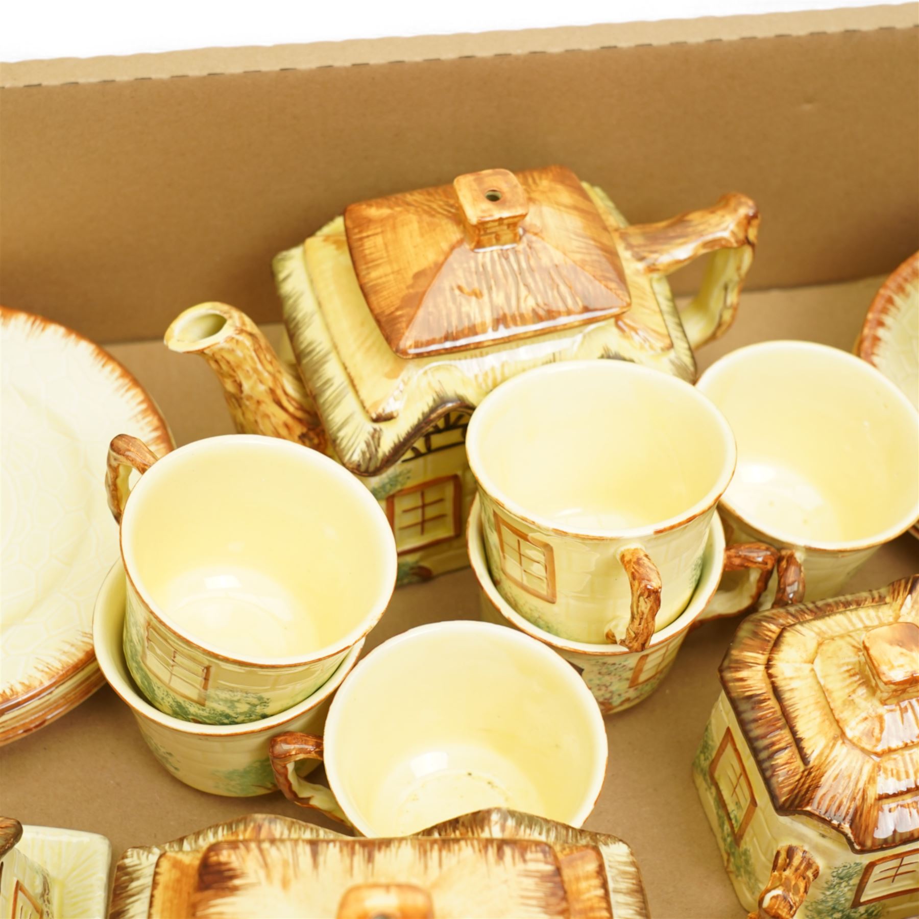 Keele St. Pottery cottage tea set comprising seven cups, six saucers, six plates, large and small teapots, butter dish, two milk jugs and two sugar bowls and covers