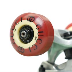 Gucci x Palace skateboard, Spring/Summer 2021, green GG monogram wood deck with multicolour ‘AH AH AH! GUCCI’ lettering and cartoon character mascot motif, fitted with Gucci-branded metal trucks and red and cream wheels, model no. 689103 JCGMN, presented with original GG monogram drawstring dust bag, protective sleeve, outer box and accompanying cards, Skateboard L81cm W20cm