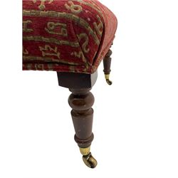 Rectangular beech framed footstool, upholstered in striped red fabric decorated with zodiac symbols, on turned supports terminating at brass castors