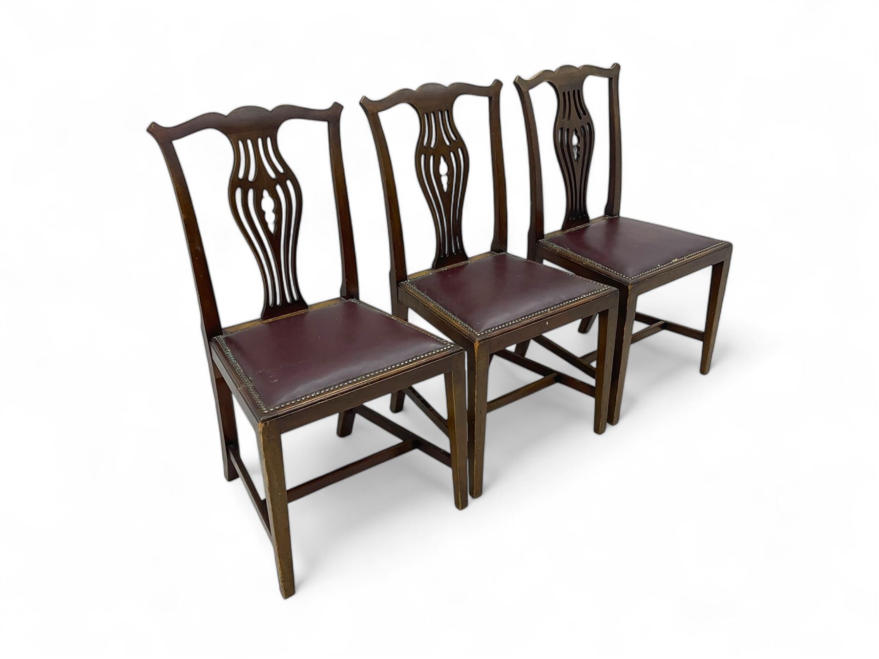 Set of six (4+2) 19th century Chippendale-design mahogany dining chairs, shaped cresting rail over pierced bulbous vase-shaped splat, burgundy leather upholstered seats with brass stud trim, on square tapering supports united by H-stretchers
