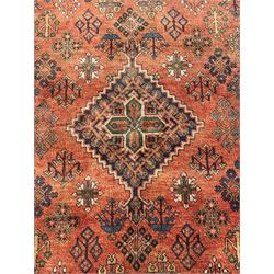 Persian Joshaghan rust ground rug, stepped lozenge medallion surrounded by repeating foliate lozenge motifs, the border decorated with stylised plant motifs, within geometric guard stripes
