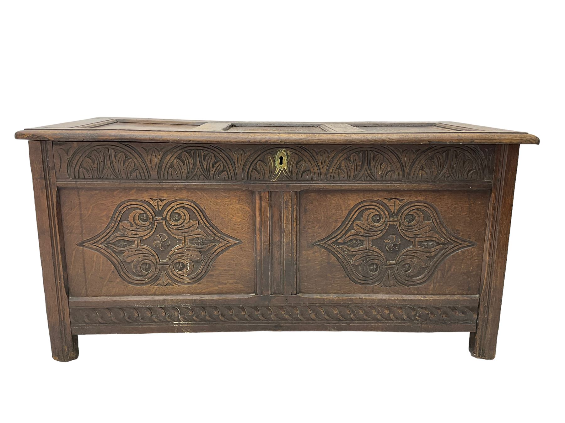 18th century oak blanket chest or coffer, rectangular hinged top with three panels and moulded edge, frieze carved with lunette and acanthus leaf decoration, two front panels carved with scrolling motif, raised on stile supports