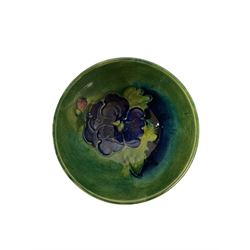 Small Moorcroft bowl decorated with dark blue flowers upon blue green ground, with impressed marks beneath