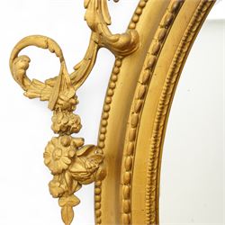 Late 19th century Louis XVI style giltwood and gesso girandole oval wall mirror, the oval frame surmounted with stylized urn finial and ribbon-tied garlands, laurel swags and rosettes, egg and dart decorated inner moulding and linked acorn outer moulding, flanked by intertwined foliate decorated candle branches 