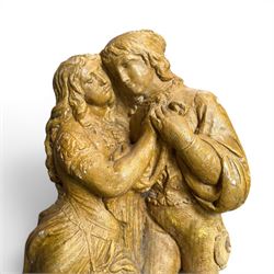 Composite garden statue group of Romeo and Juliet embracing in Medieval dress, surmounted on a naturalistic foliate base, in antique distressed glazed finish