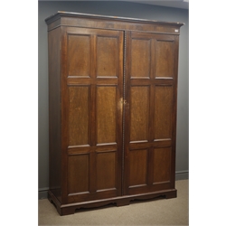  Edwardian mahogany double wardrobe, projecting cornice, two panelled doors enclosing fitted interior, shaped plinth base, W139cm, H195cm, D54cm  
