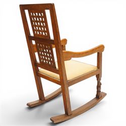 Mouseman - 1940's dark-honey oak rocking chair, high back with pierced double-lattice panel, over a beige-leather upholstered seat, shaped arm terminals above turned octagonal front-supports united by rocker base, with carved mouse signature, by the workshop of Robert Thompson of Kilburn