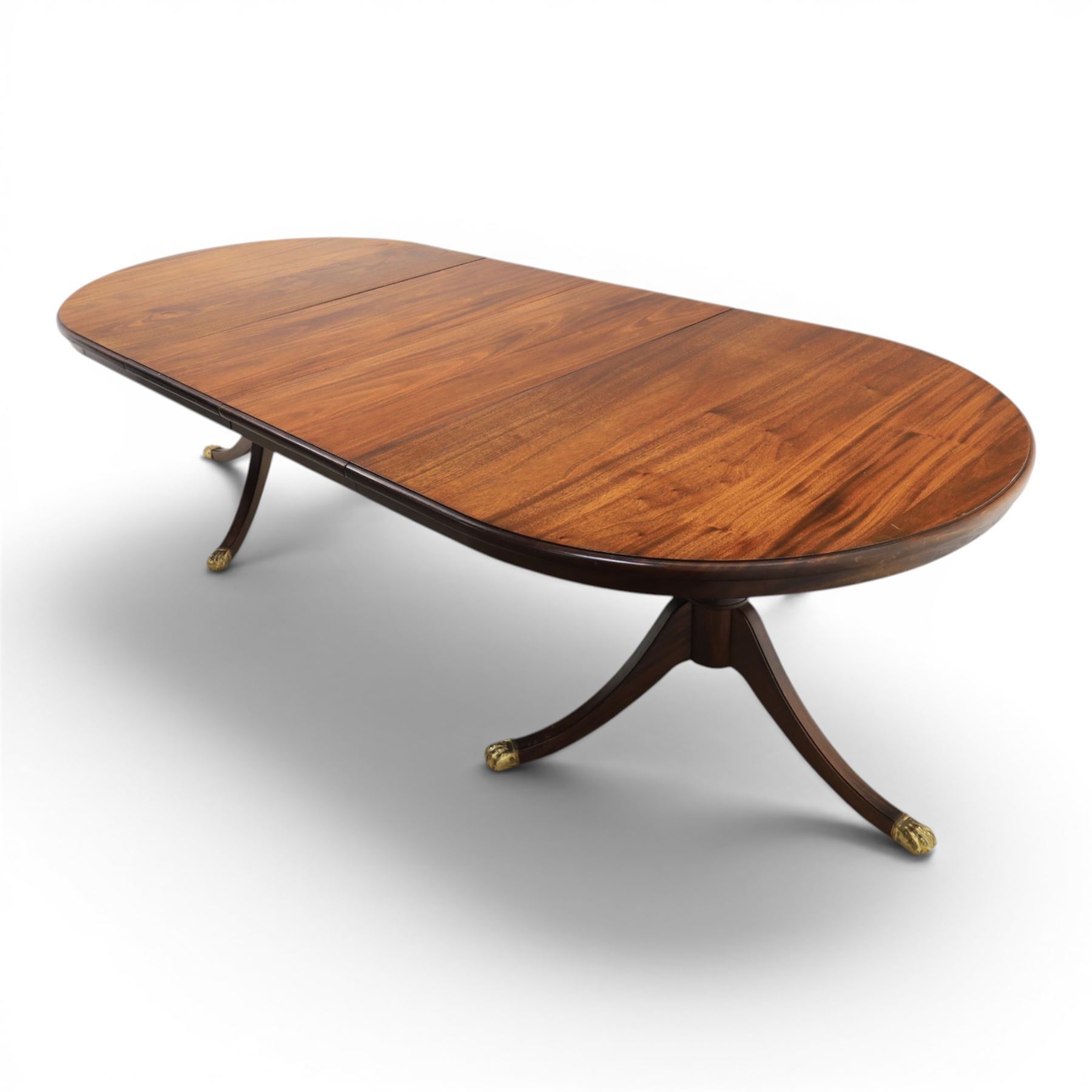 Regency design mahogany extending twin pedestal dining table with two additional leaves, raised on splayed supports terminating brass paw feet
Extends to 268cm