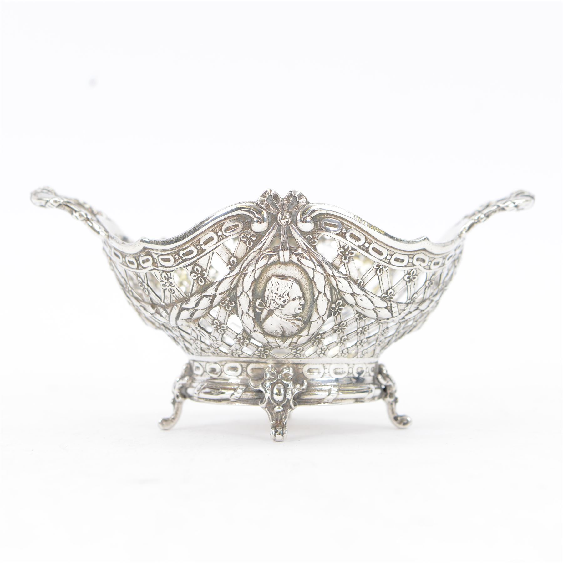 Late 19th/early 20th century German Hanau silver basket, modelled in George II style, of shaped openwork lattice form with twin handles, the body decorated with two portrait roundels and husk and ribbon swags, upon four scroll feet, with unattributed pseudo Hanau marks, and hallmarked John George Piddington, London import 1901, including handles H7cm W15cm
