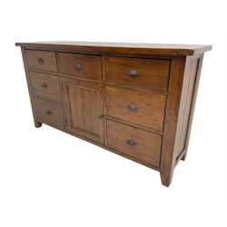 Stained pine rustic sideboard, rectangular top over seven drawers and single panelled cupboard, fitted with shell handles