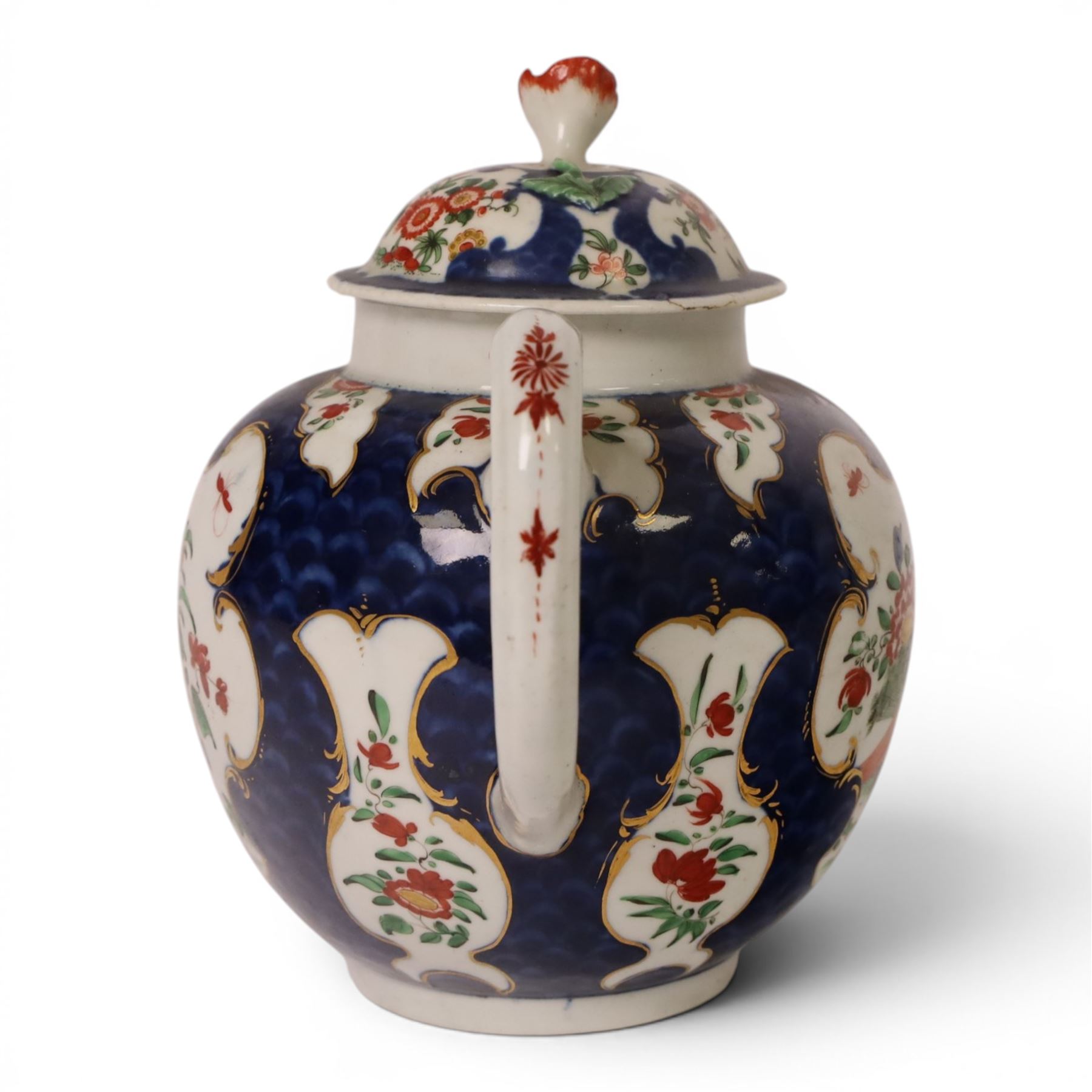 18th century Worcester teapot, circa 1763-70, of globular form, painted with shaped panels of chrysanthemums and banded hedges on a blue scale ground, cover with flower finial, mark beneath, H15cm
