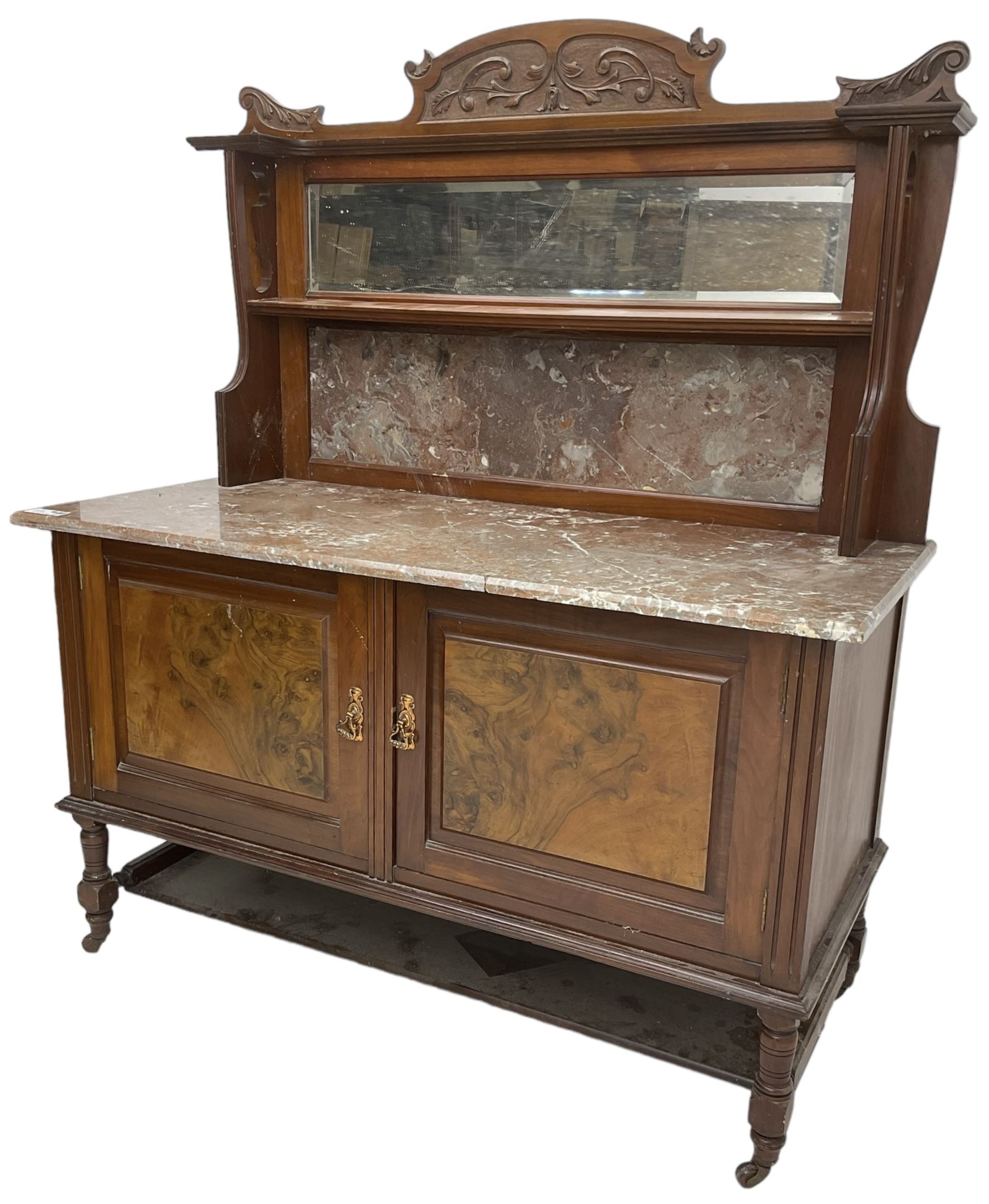 Late Victorian walnut washstand, raised back with carved pediment over bevelled mirror and marble panels, rectangular marble top, fitted with two figured panel doors, on turned supports