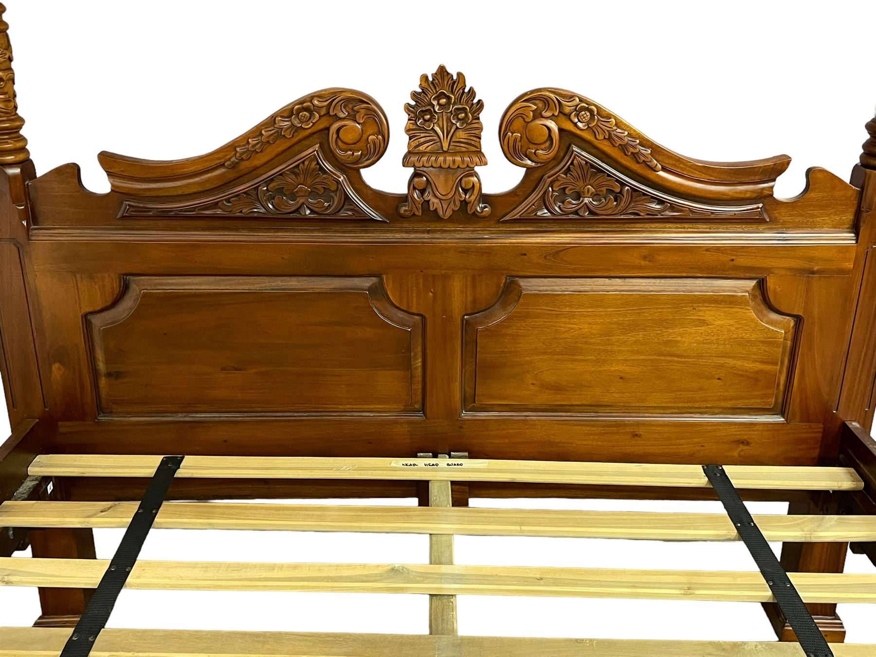 Georgian design mahogany 5' King-size four-poster bed, projecting moulded canopy top on twist-turned columns carved with acanthus leaves and flower heads, the headboard with scrolled broken swan neck pediment carved with scrolled foliage and with central anthemion, on flower head carved ball and claw front feet, with torch and foliate carved pointed finials