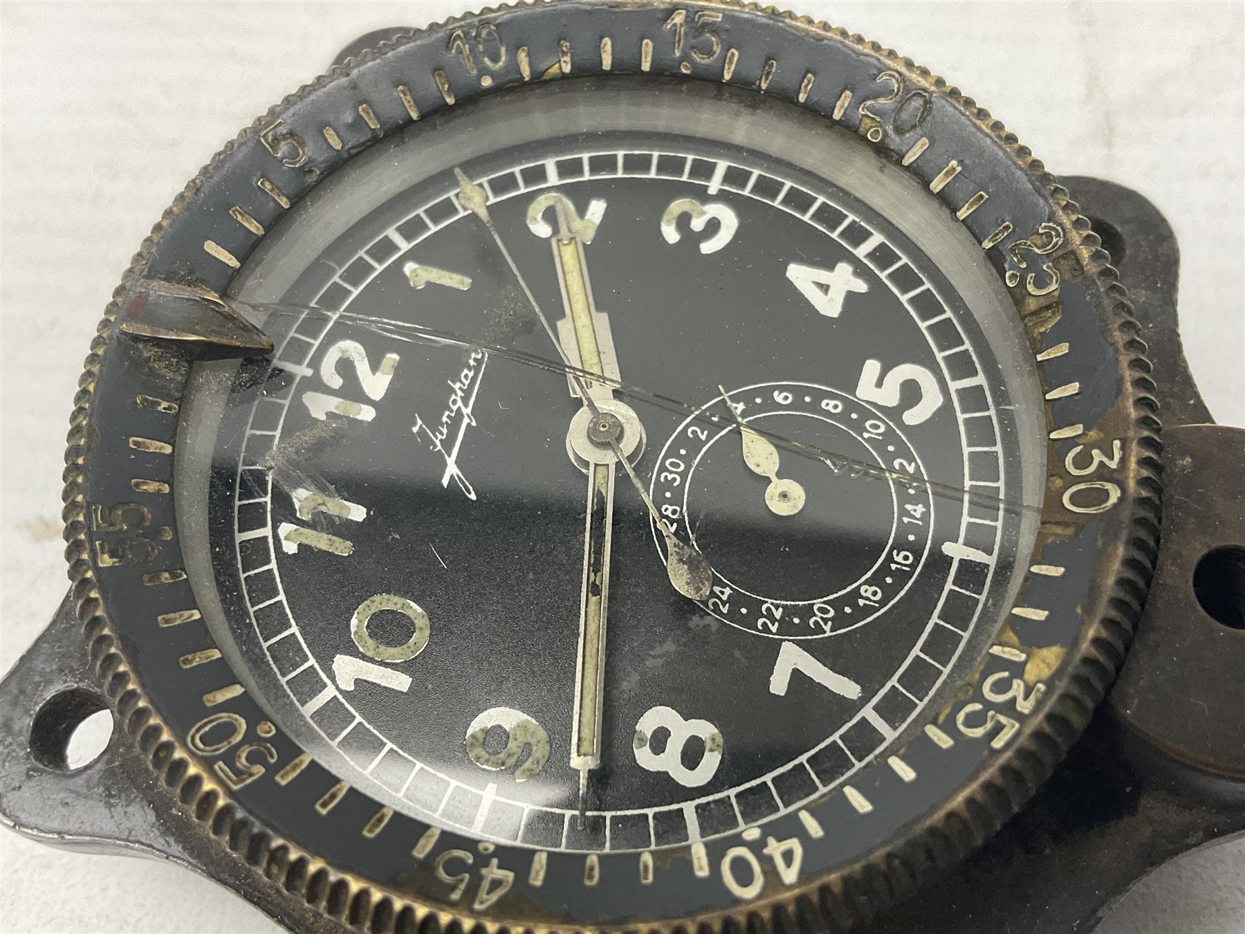 WW2 Jungans Luftwaffe aircraft cockpit clock with luminous centre sweep seconds hand, baton hour and minute hands, regulation 45mm black dial with date recorder, formerly illuminous Arabic numbers and minute track, rotating bezel (seized), going barrel movement with a lever escapement serial No 22901 jewelled to the centre wheel, over-sprung balance with timing  screws, max.H8cm