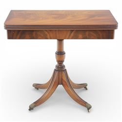Victorian design mahogany card table, rectangular top with swivel and fold open action, revealing a baized lined interior, raised on turned baluster column, with reeded legs terminating in brass paw castors 