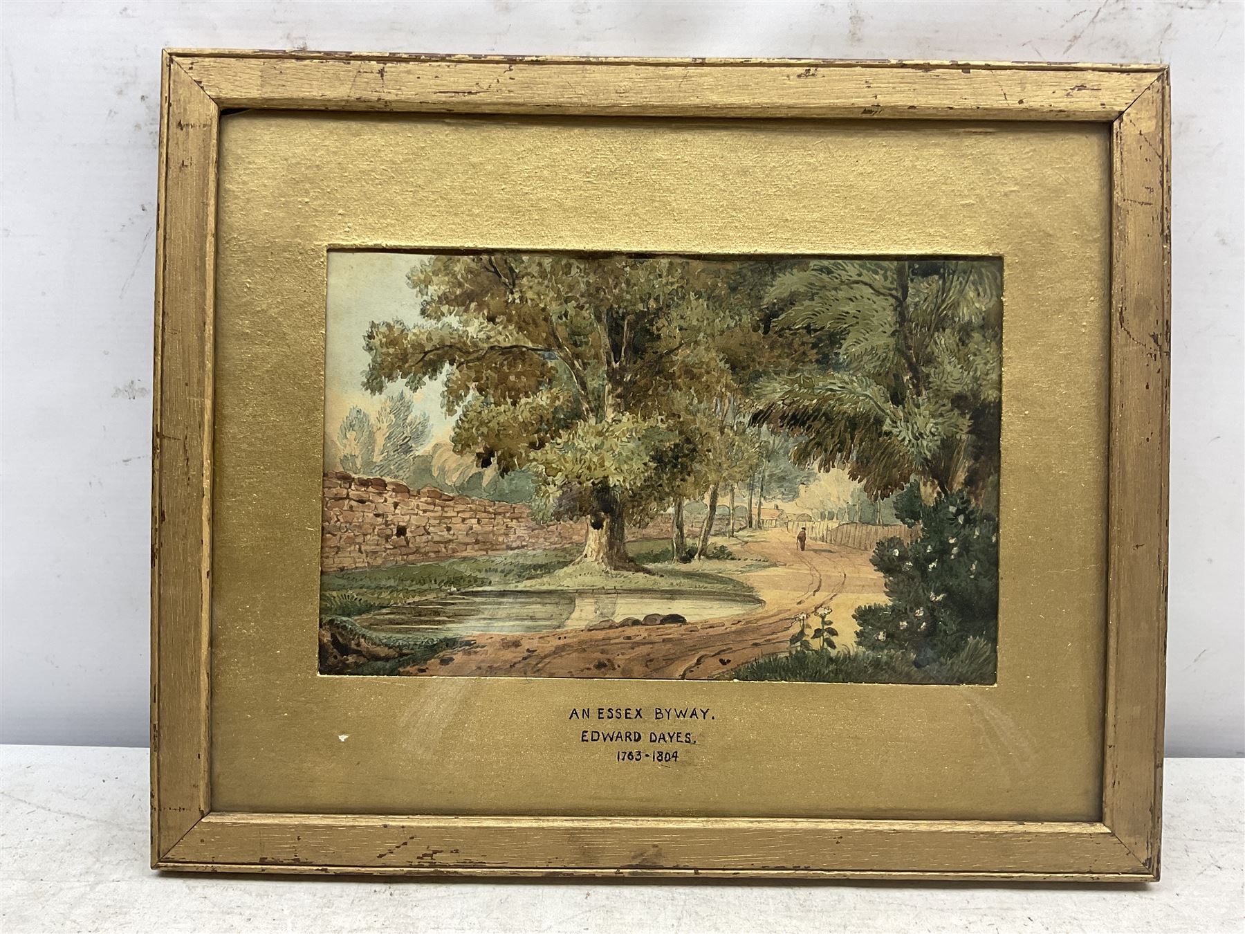Attrib. Edward Dayes (British 1763-1804): 'An Essex Byway', watercolour titled and attributed on the mount 17cm x 27cm; After Georges Redon (French 1869-1943): 'Ne Buvez Jamais D'eau' - 'Never Drink Water', lithograph from the 'Naughty Children' series 44cm x 31cm; together with a Louis Wain print 12cm x 20cm (3)