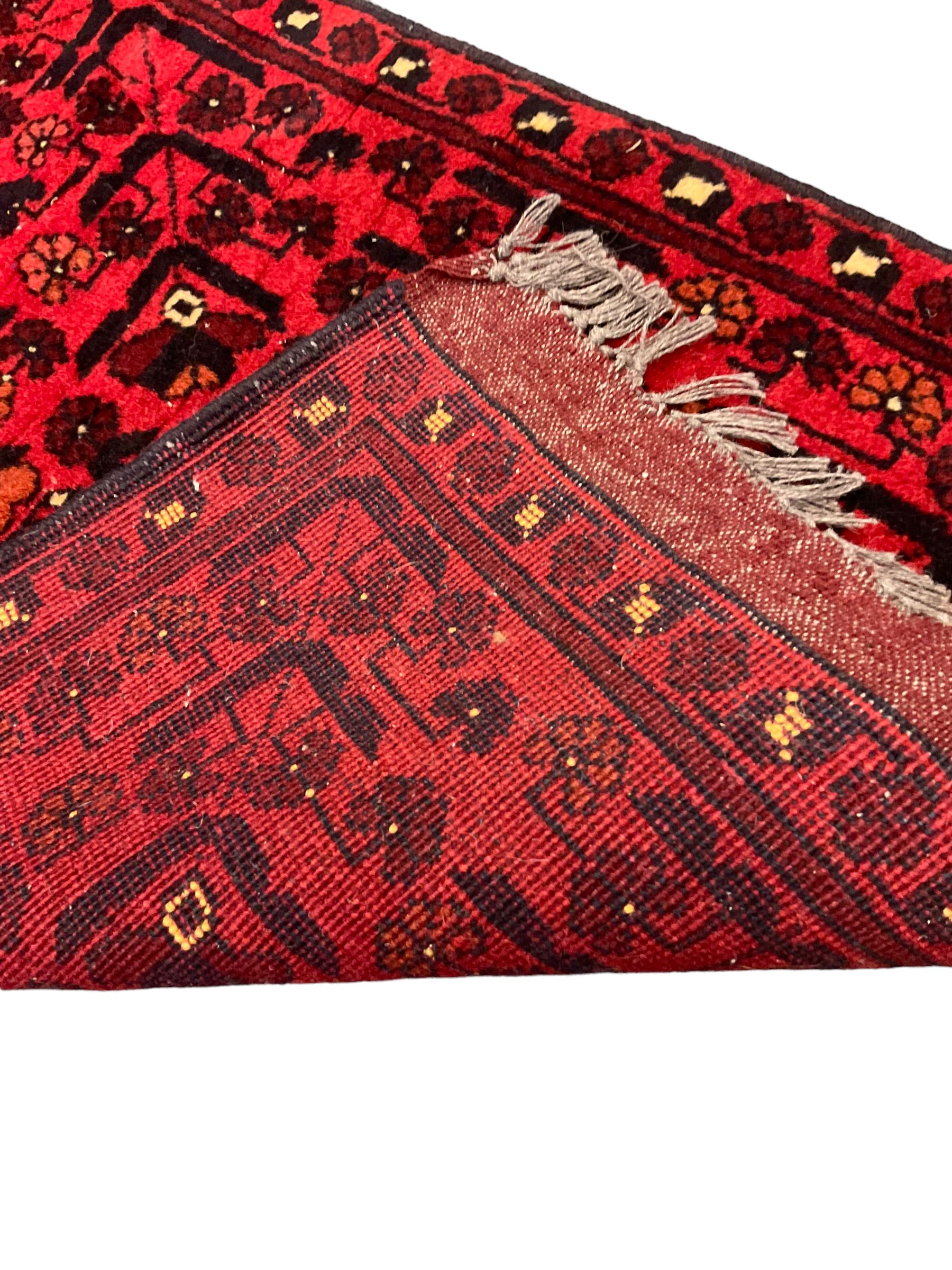 Small Persian magenta ground rug, central Mirab with flanking columns enclosing stylised urn motif with trailing foliage, the triple band border with plant motifs (86cm x 46cm); Persian red ground rug, two central floral medallions with extending flower heads, floral decorated border (106cm x 53cm) (2)