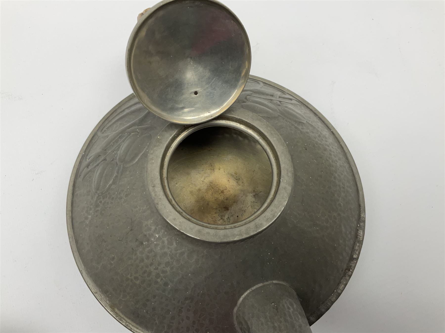 Archibald Knox for Liberty & Co Tudric pewter three piece tea service, comprising teapot with woven reed handle, single handled open sucrier, and milk jug, each with planished finish and detailed with honesty flowers, each impressed beneath Made in England Tudri Pewter 0231 