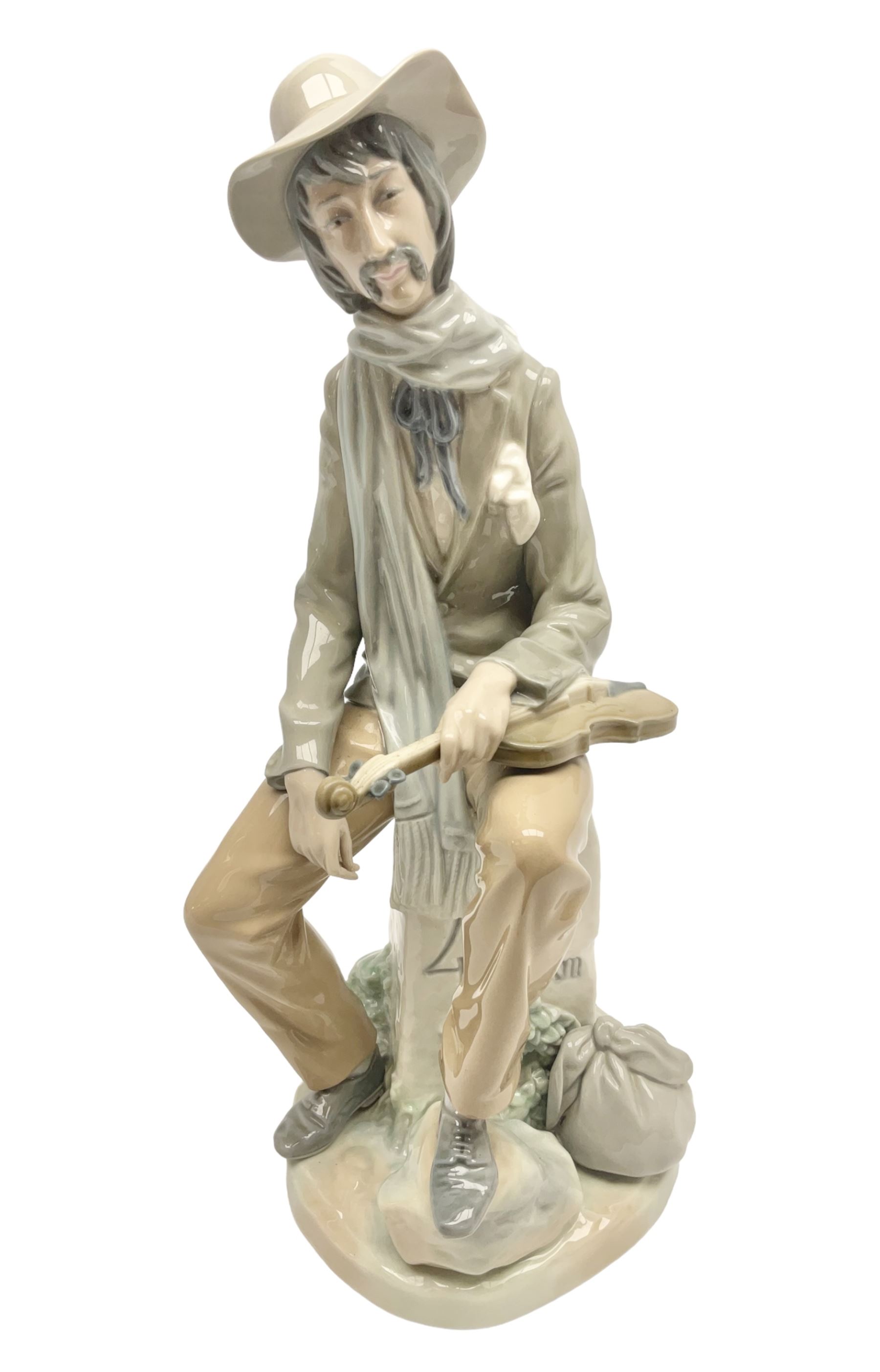 Lladro figure, Violinist, modelled as a man seated upon a  mile stone holding a violin, sculpted by Salvador Furió, no 4887,  year issued 1984, year retired 1981, H35cm