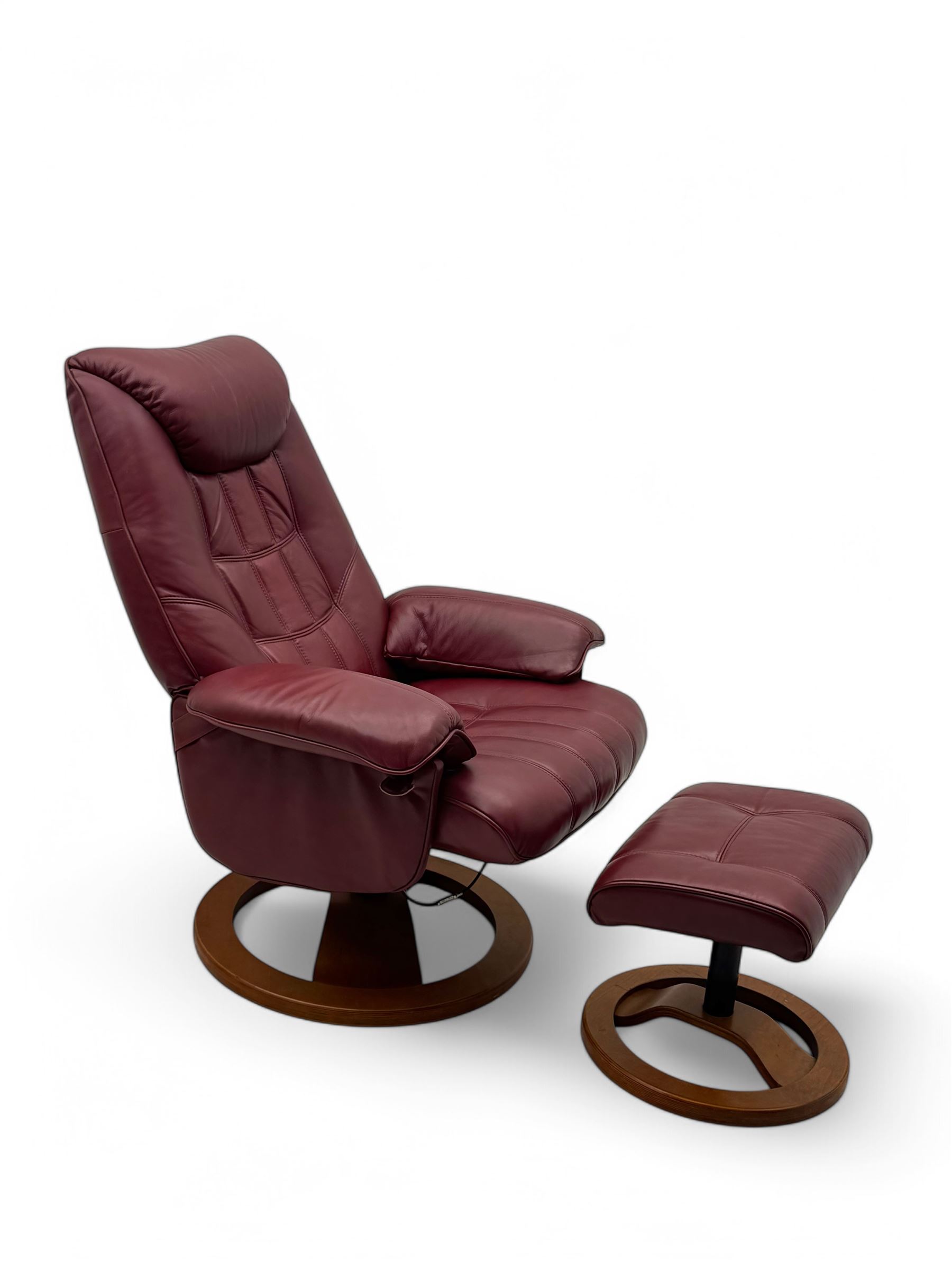 Contemporary burgundy leather reclining armchair and footstool, featuring segmented upholstered cushions and padded armrests, each piece mounted on a circular laminated wood base