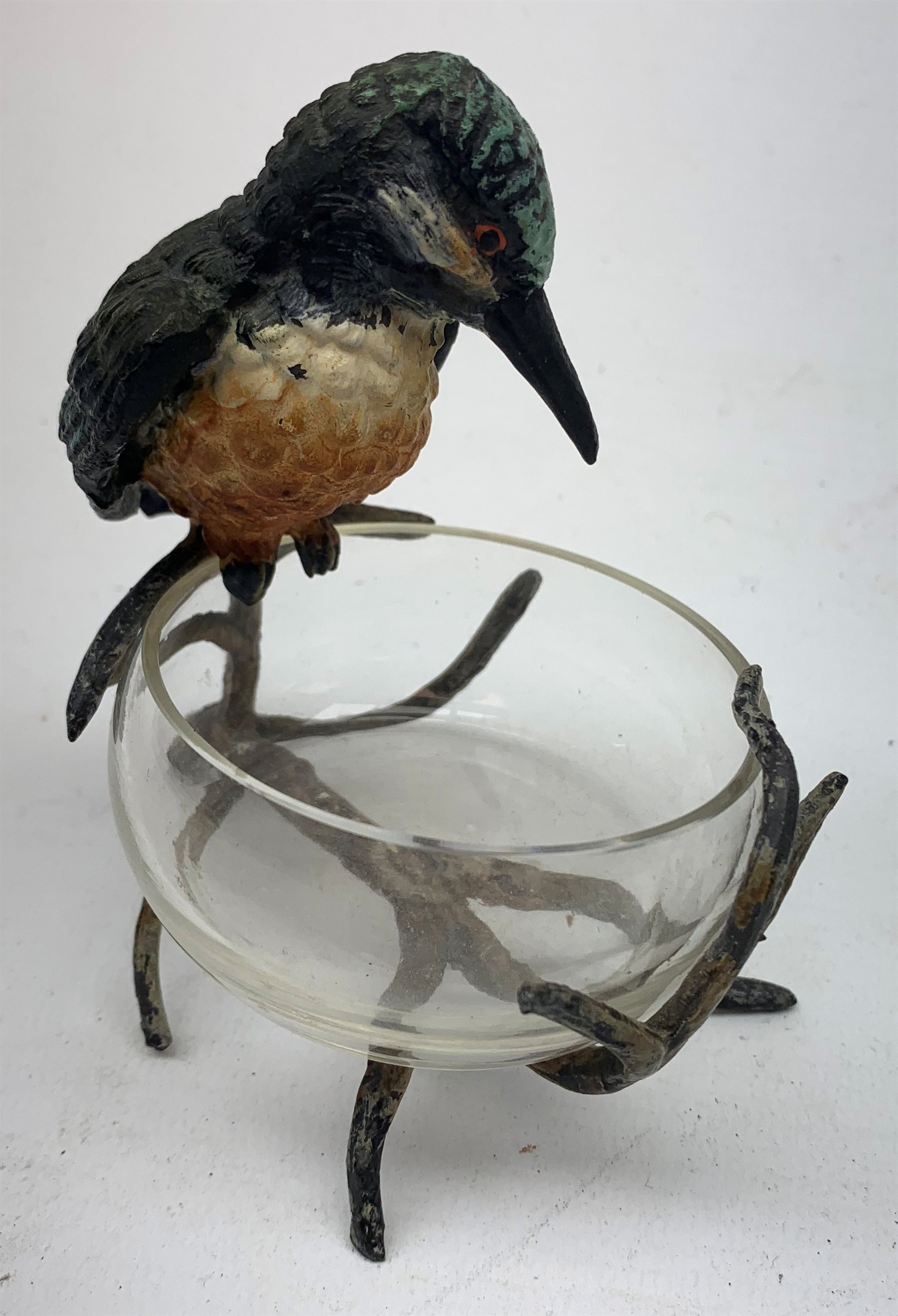 A cold painted model of a Kingfisher surmounted upon a branch surporting a small clear glass bowl, H10.5cm, together with a small bronze model of a penguin, stamped EWB, H7cm. 