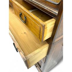 Late Meiji-period Japanese keyaki wood tansu chest, upper section with six sliding woven rattan doors over five drawers, lower section fitted with an asymmetrical arrangement of seven drawers and side cupboard with a hinged door enclosing three additional drawers, iron drop handles to sides