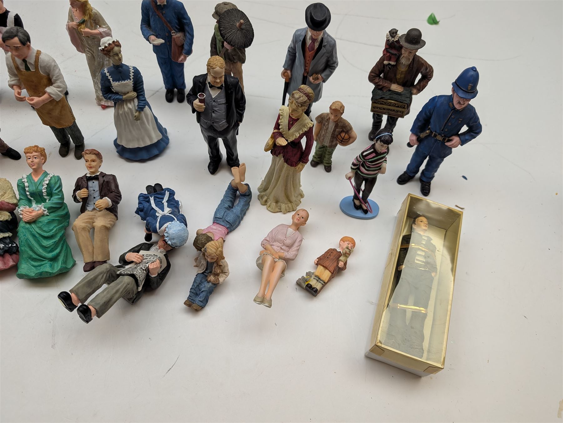 1:12 scale dolls house composite figures, including policeman, postman, maid, sitting and standing people in various styles of dress, etc
