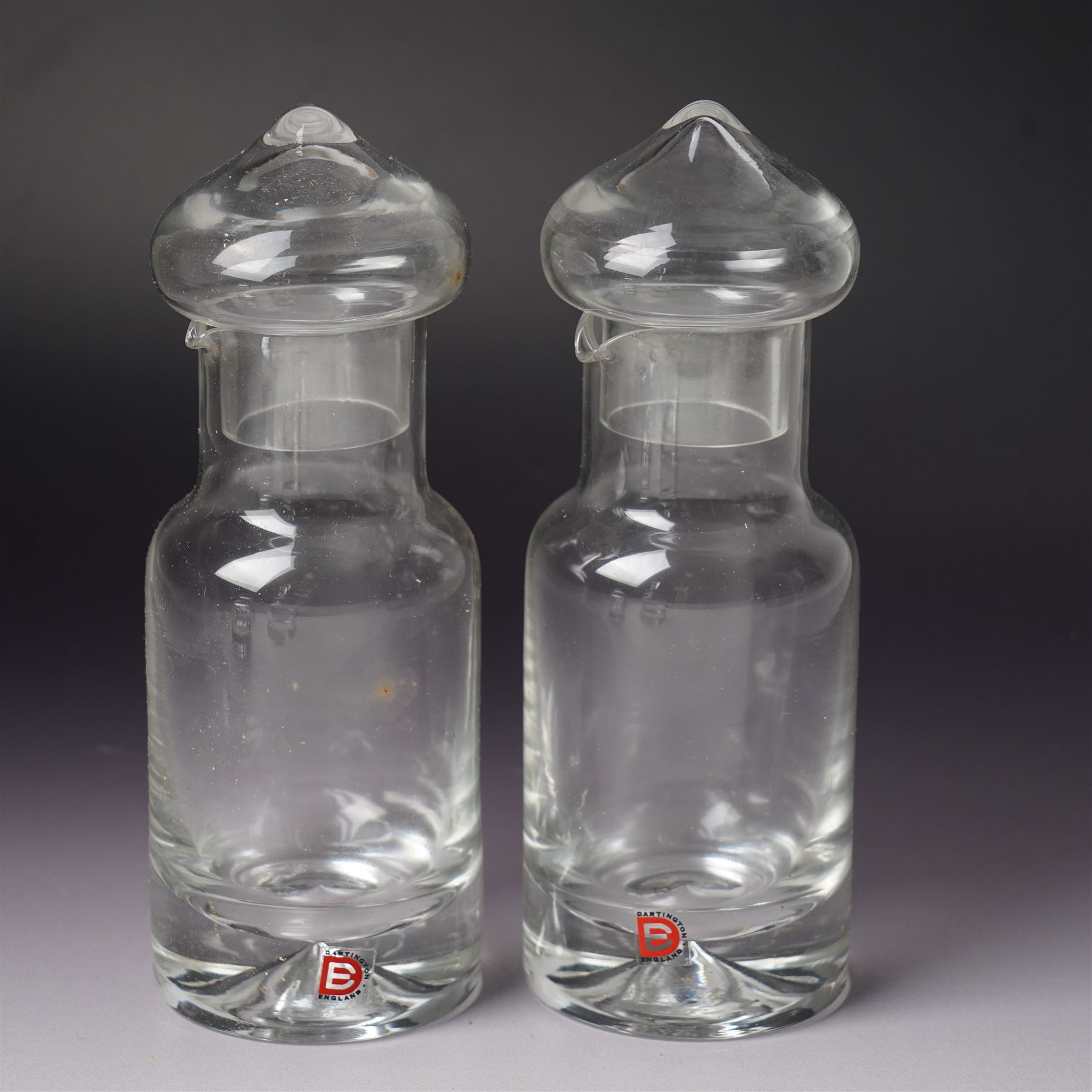 Three Dartington Crystal examples designed by Frank Thrower, comprising two oils and vinegar bottles, and one decanter, together with a covered jar with spoon designed by Palona Picasso for Villeroy & Boch, all boxed (3)