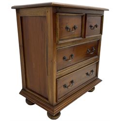 20th century hardwood chest, fitted with two short over two long drawers with moulded facias, lower moulded edge over large bun feet