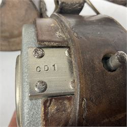 Metal cased drum shaped travelling clock with grey hammered finish, French clockwork movement and stitched leather outer case with shoulder strap; bears manuscript label 'Royal Armament Research and Development Establishment - serial no.09433' D13cm overall