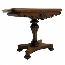 Victorian rosewood card table, swivelling rounded rectangular fold over top with moulded edge, the shaped apron with applied carved scroll and cartouche mounts, lobe carved pedestal support on shaped platform, turned and carved feet with recessed castors 