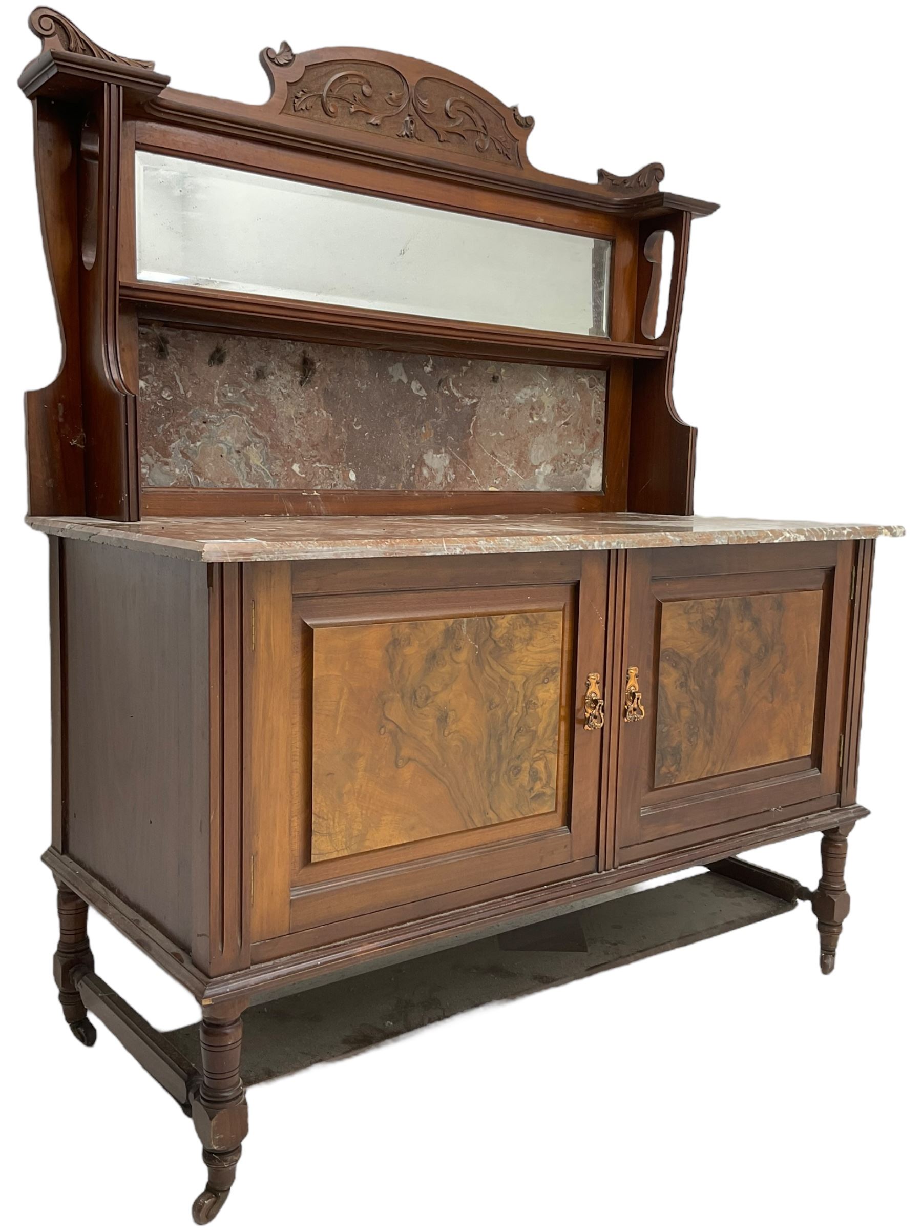 Late Victorian walnut washstand, raised back with carved pediment over bevelled mirror and marble panels, rectangular marble top, fitted with two figured panel doors, on turned supports