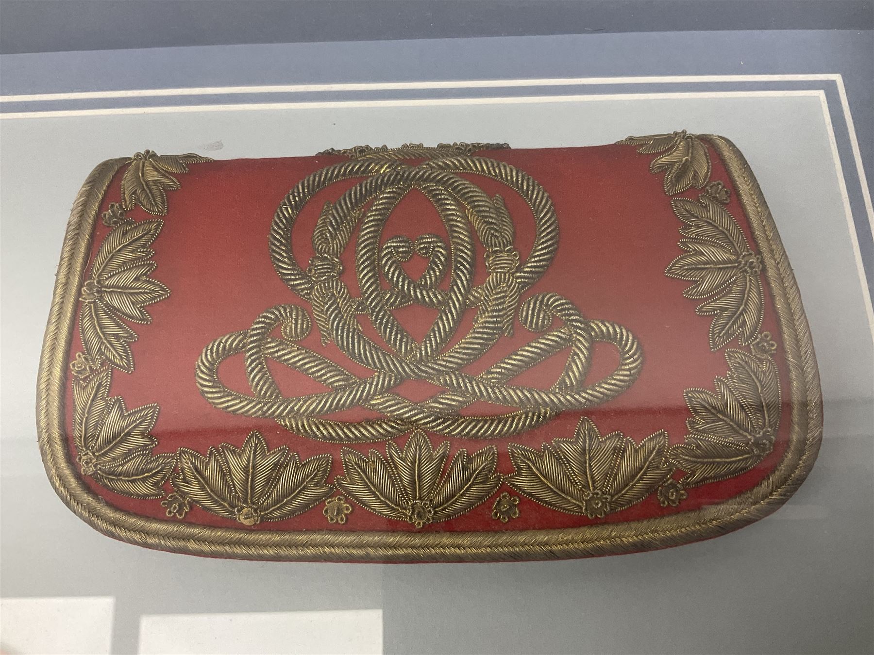 Victorian / Edward VII Queens Own Hussars Officers Full Dress Pouch and Cross Belt; scarlet cloth covered leather pouch with bullion embroidered crown, laurel bordered regimental crest within an edge of embroidered bullion wire; with its original officers cross belt with fine regimental pattern brocade to the top and gilt metal furniture; displayed in a wall hanging case with cloth and metal regimental badges; mahogany stained frame 44 x 54cm