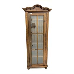 Stained wood display cabinet, shaped and moulded top, panelled glazed door enclosing six shelves, raised on turned supports 